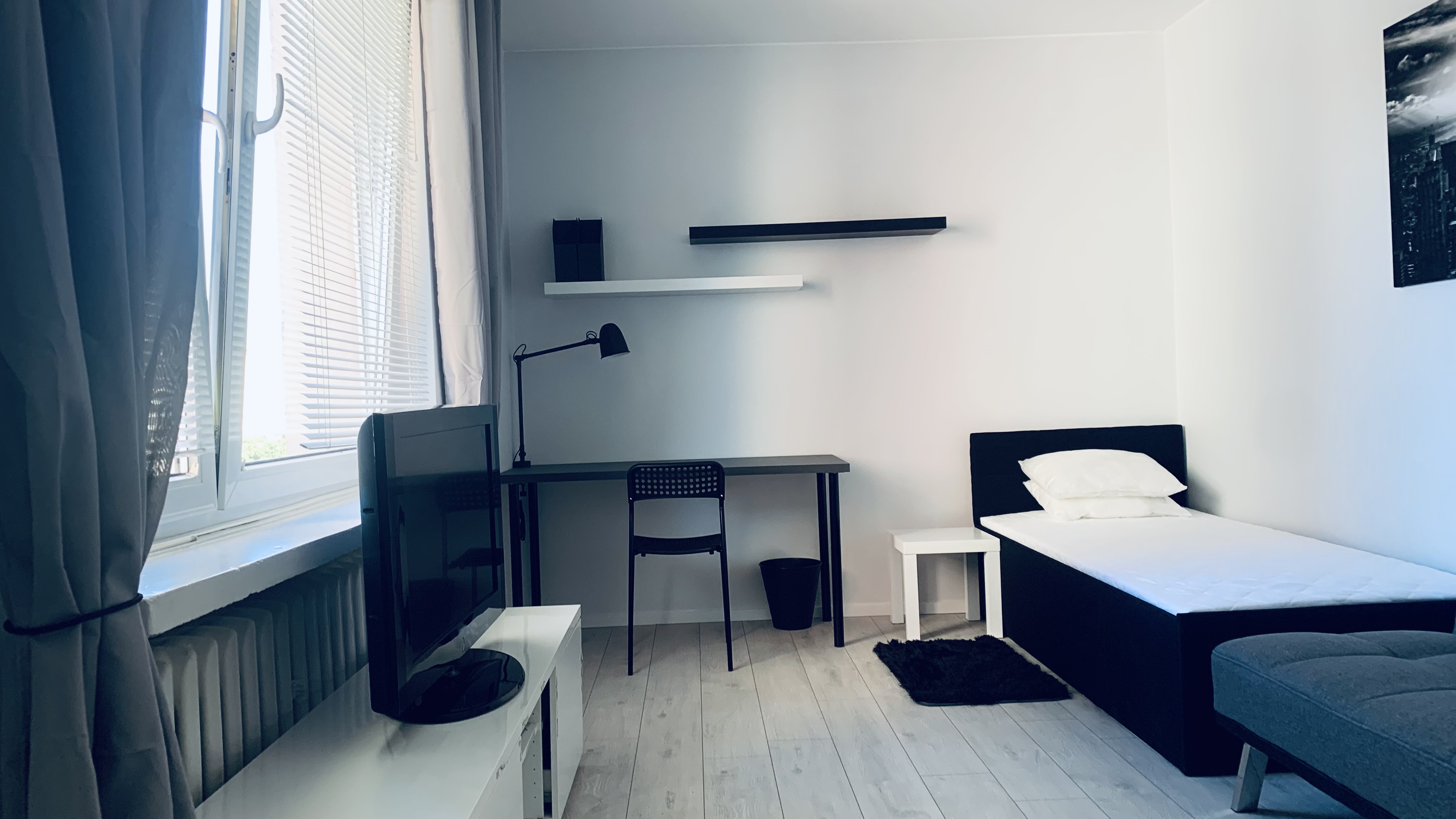 Bed, desk and window in Borowska room #2