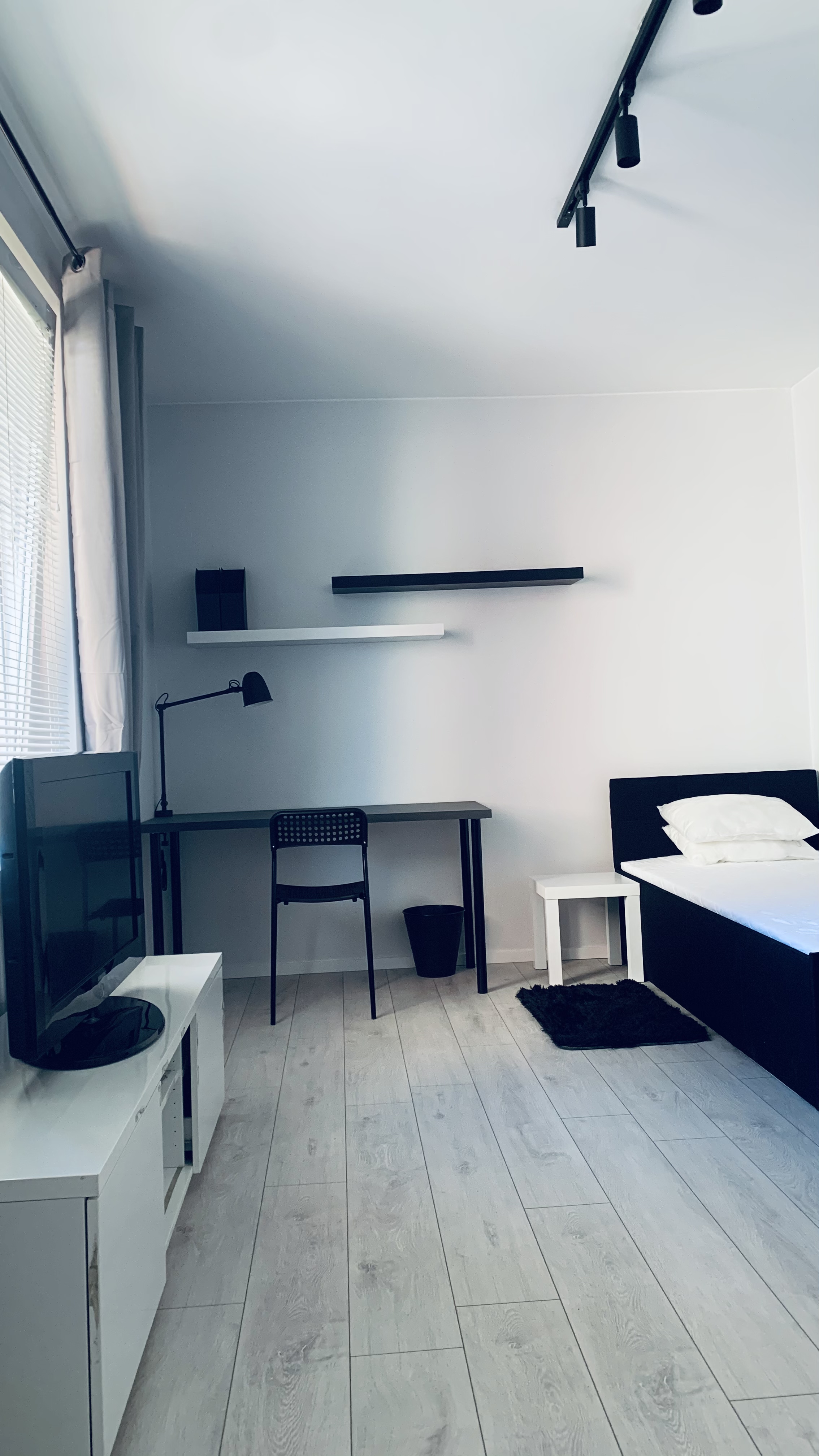 Full-height view of the room and bed