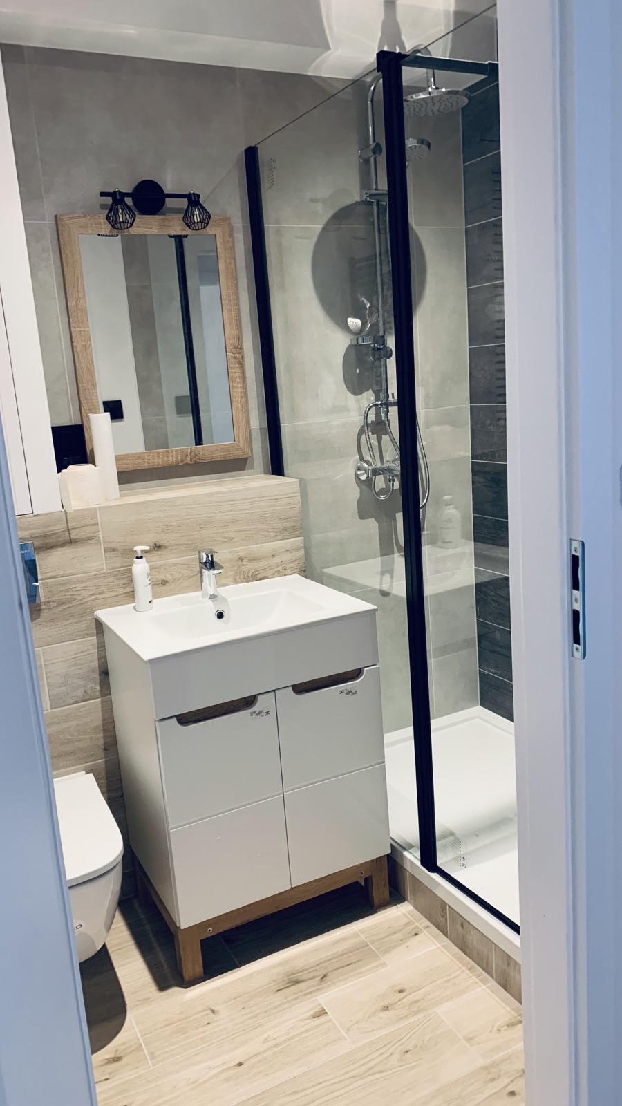 Shower and sink in the shared Borowska apartment bathroom