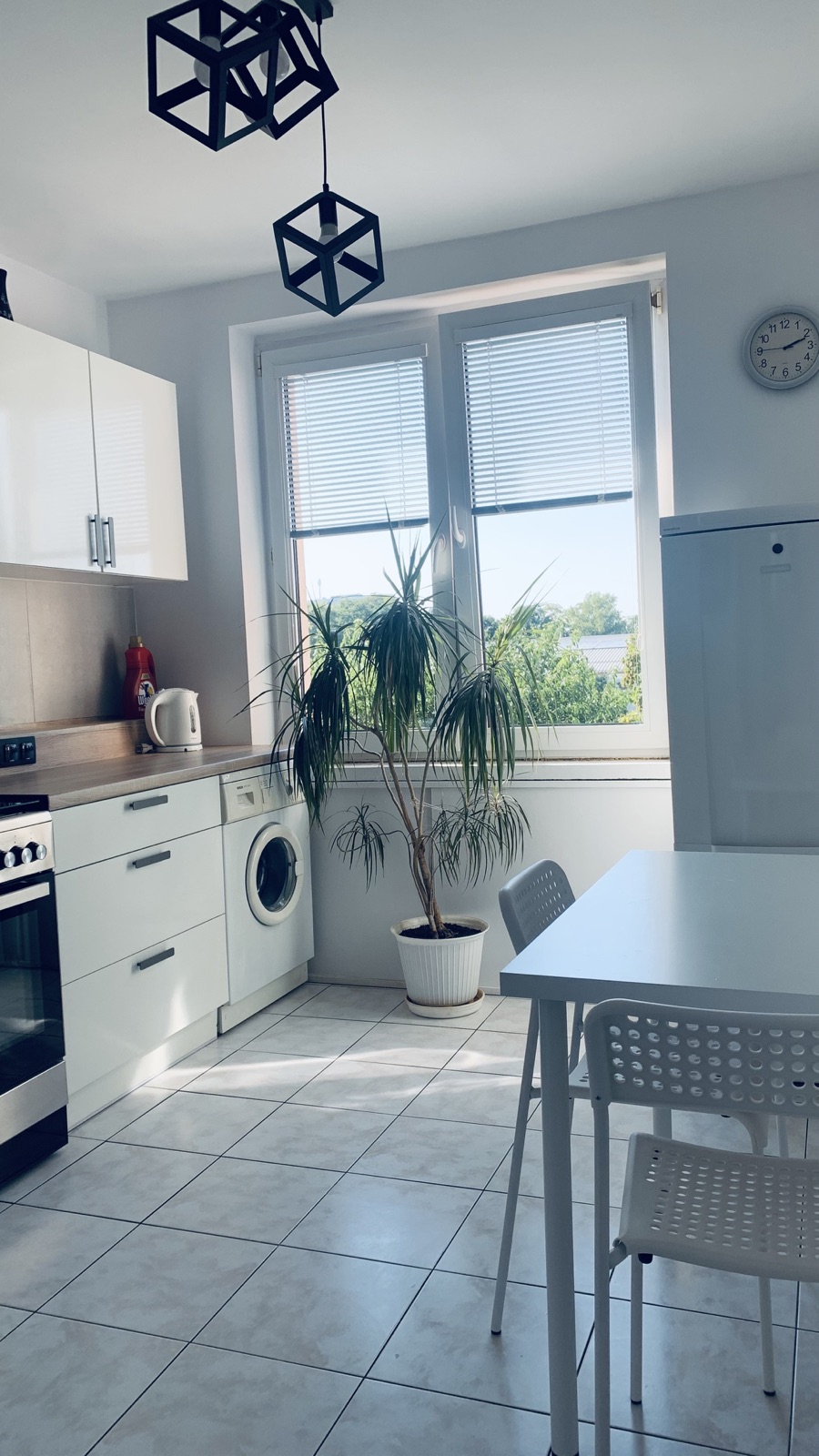 Dining table by the window in the shared Borowska apartment kitchen