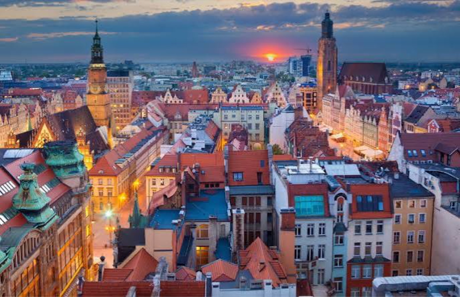 Rooftops and church towers across central Wrocław at sunset