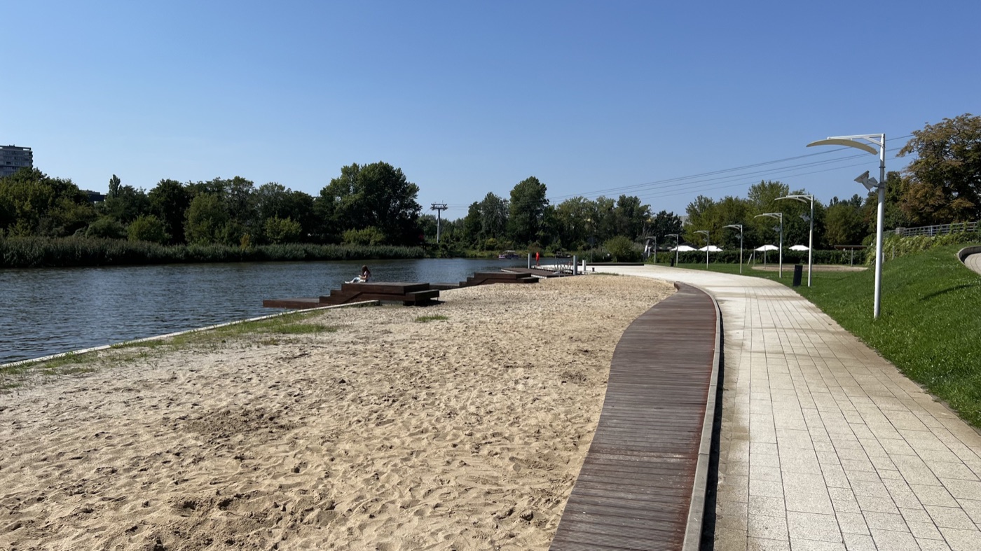 A sandy riverside beach and walking path